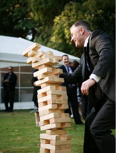 Giant Jenga wooden stacking game collapses and man laughs